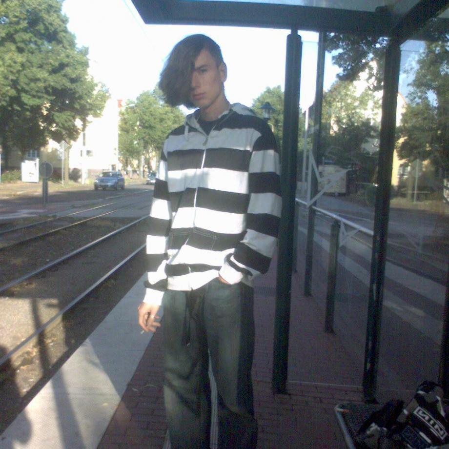 Emo Joe Jojo mit Sidecut an einer Straßenbahnhaltestelle